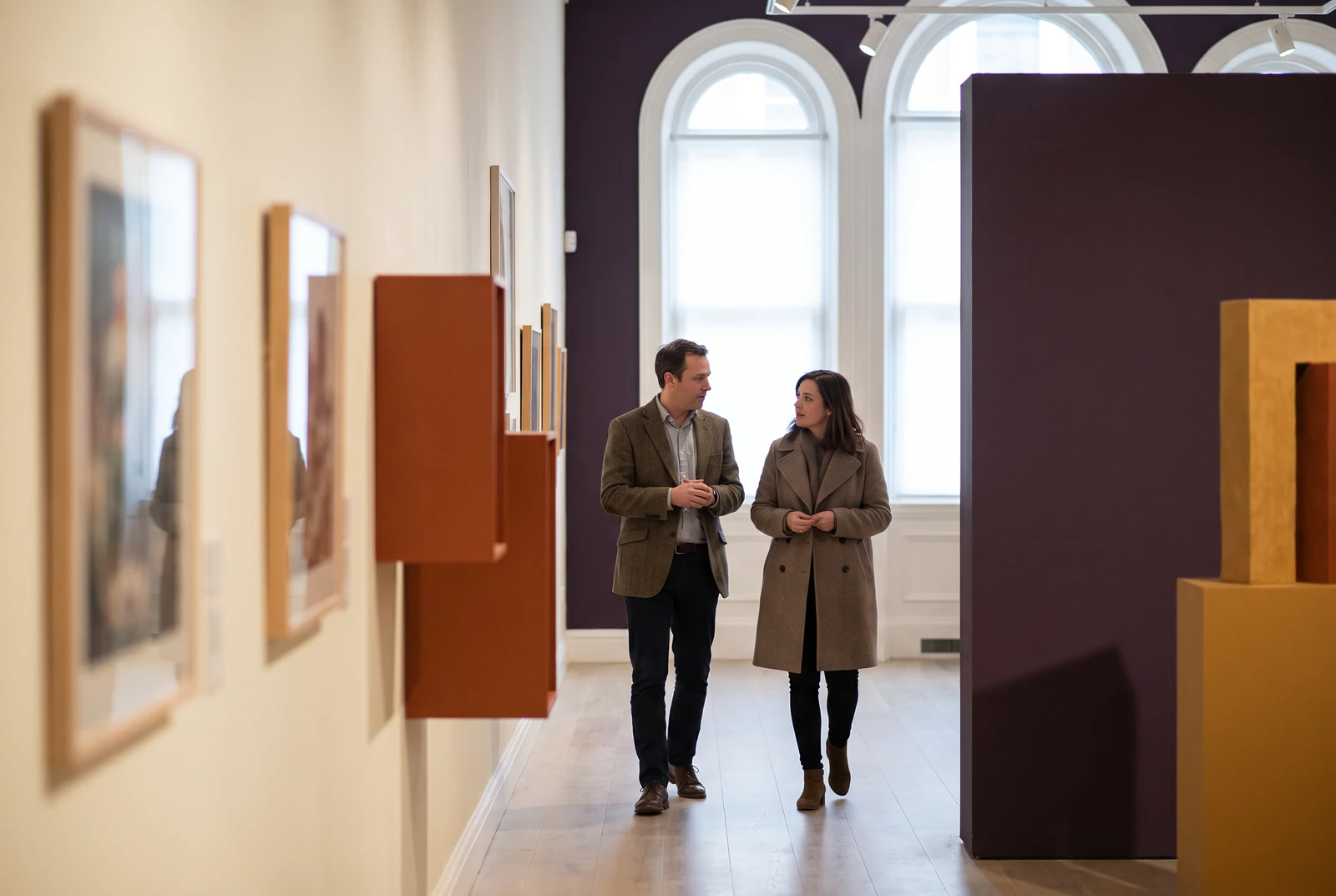 Two people in conversation while walking through a gallery